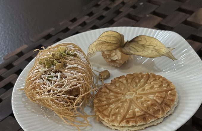 Kataifi pastry with pistachios, decorated cookie, and physalis garnish on a white plate at Barbacana