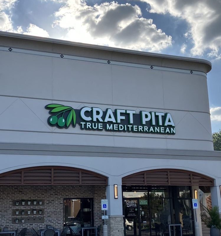 Exterior storefront of Craft Pita with green signage on Fountain View in Houston