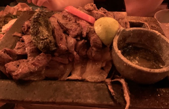 Sizzling beef fajitas on a hot platter with lime and salsa at El Tiempo Cantina