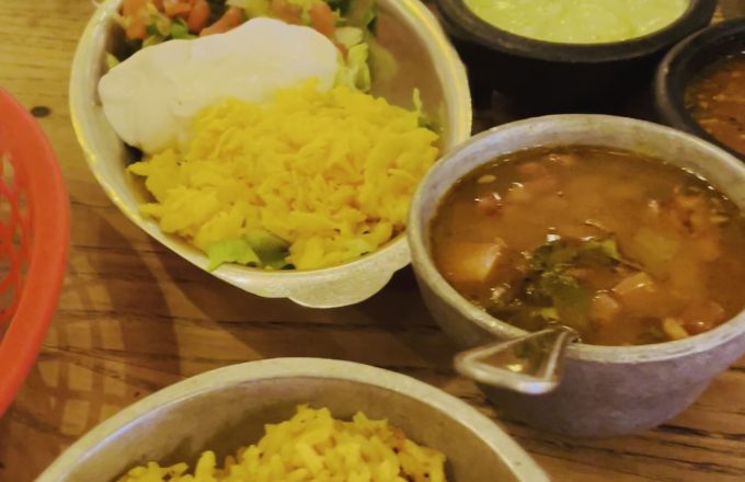 Fajita side dishes with rice, beans, guacamole, salsas, and fresh tortillas at El Tiempo Cantina
