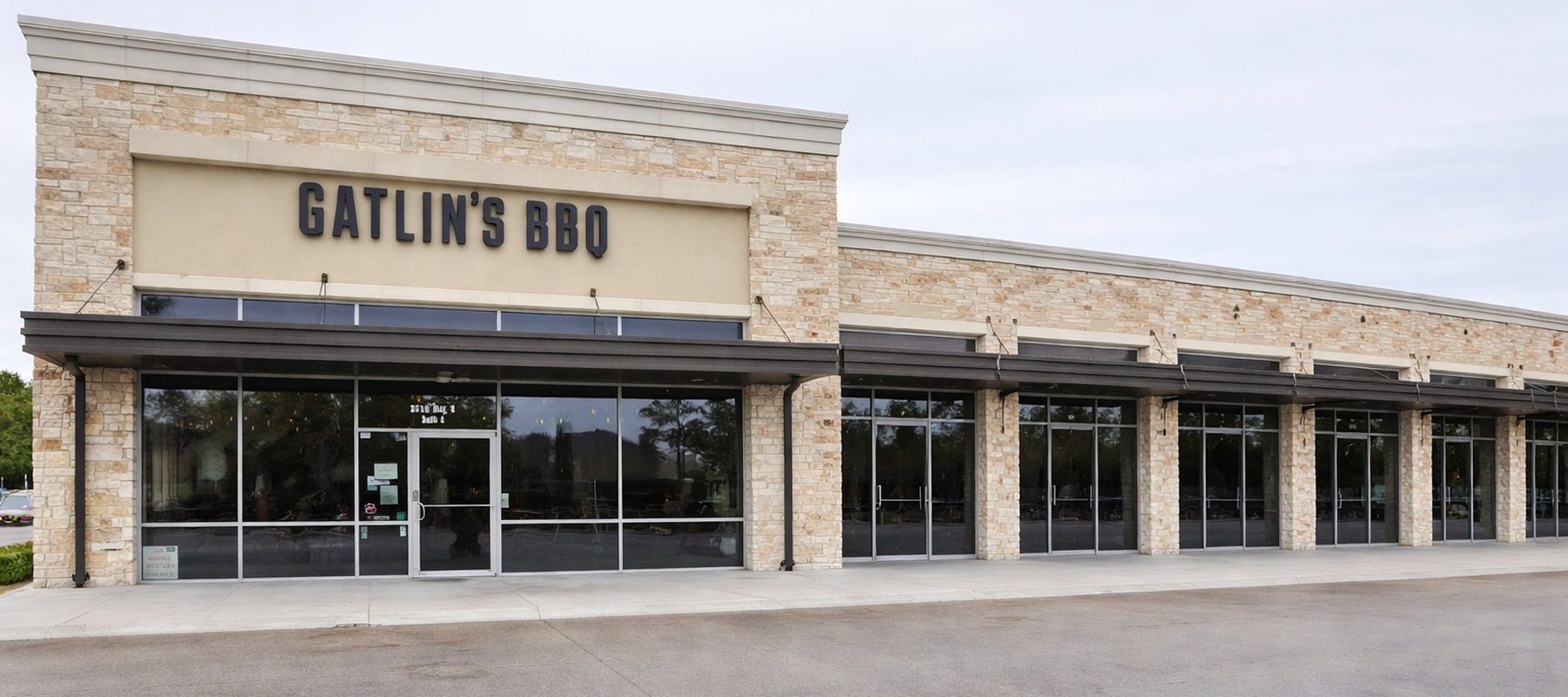 Exterior of Gatlin's BBQ restaurant with stone and stucco facade and large sign on Ella Boulevard in Houston