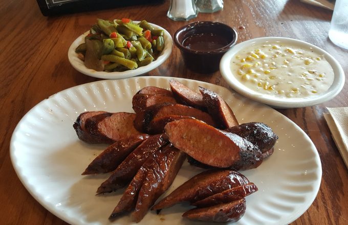 Sliced sausage plate with green beans creamed corn and barbecue sauce at Gatlin's BBQ