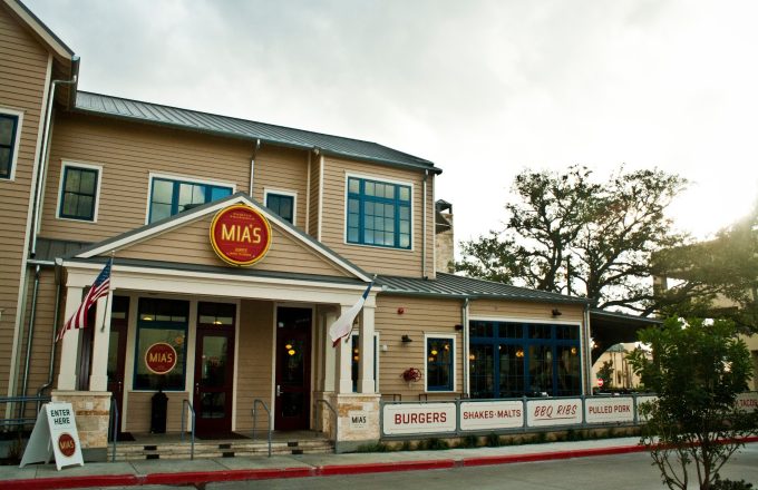 Mia's Table Upper Kirby restaurant exterior with red and gold sign American flag and menu banners on Argonne Street in Houston