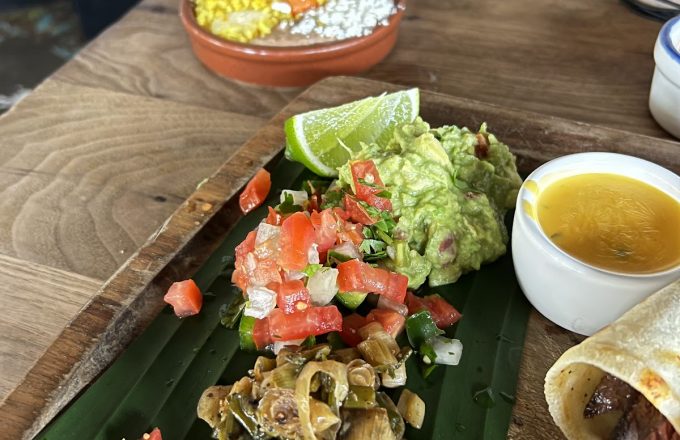 Fajita platter with guacamole, pico de gallo, and grilled peppers served on banana leaf at Ninfa's on Navigation