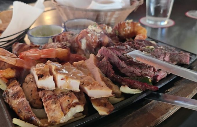 Sizzling parrillada platter with grilled beef, chicken, shrimp, and bacon-wrapped quail at Ninfa's on Navigation