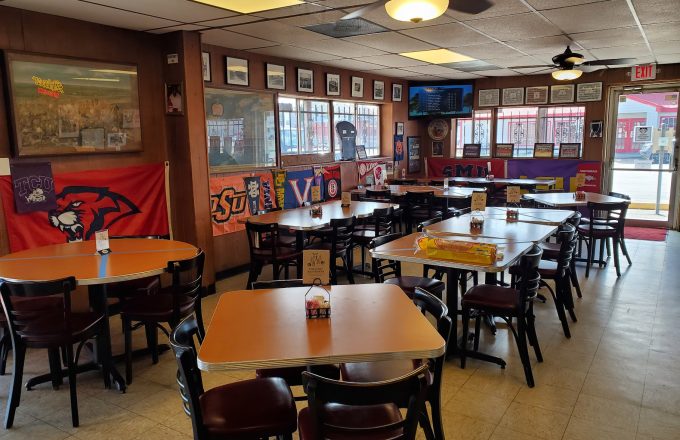 Dining room with ceiling fans and college pennants at Pizzitola's Heritage BBQ