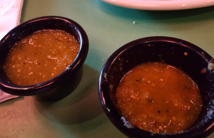 Two small bowls of house salsa on a green table at Rio Grande Tex-Mex Grill