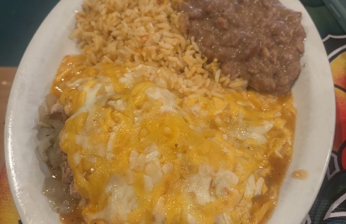 Cheese enchiladas with rice and refried beans on a white plate at Rio Grande Tex-Mex Grill