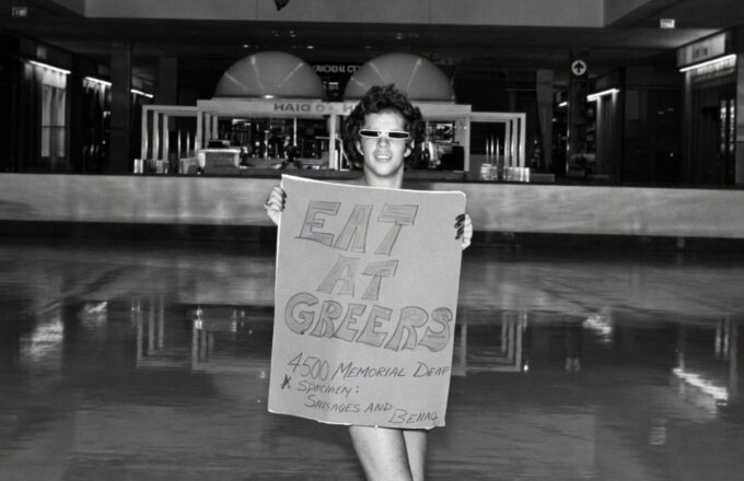 A senior-year Eagle poses on the Galleria ice rink floor with a hand-lettered sign reading "EAT AT GREER'S — 4500 MEMORIAL DRIVE — Specimen: Sausages and Beans." One of the more memorable yearbook gags honoring the school's unofficial MVP of the lunch line.